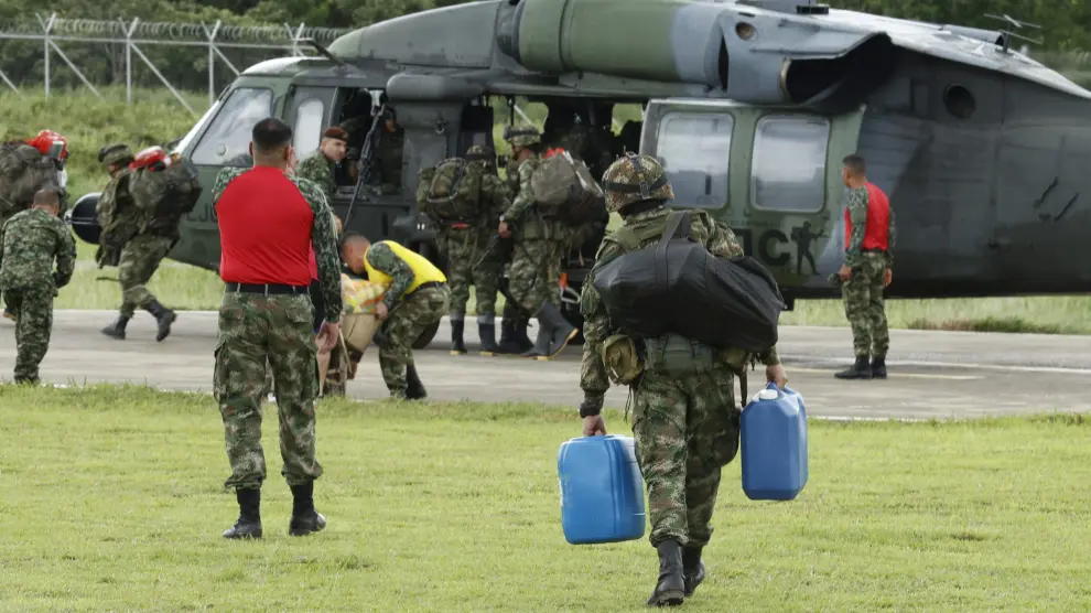 Varios soldados llevan los kits de emergencia a un helicóptero.