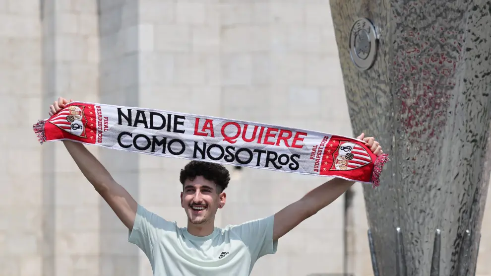 Un seguidor del Sevilla FC posa junto a una réplica del trofeo de la Europa League en Budapest.