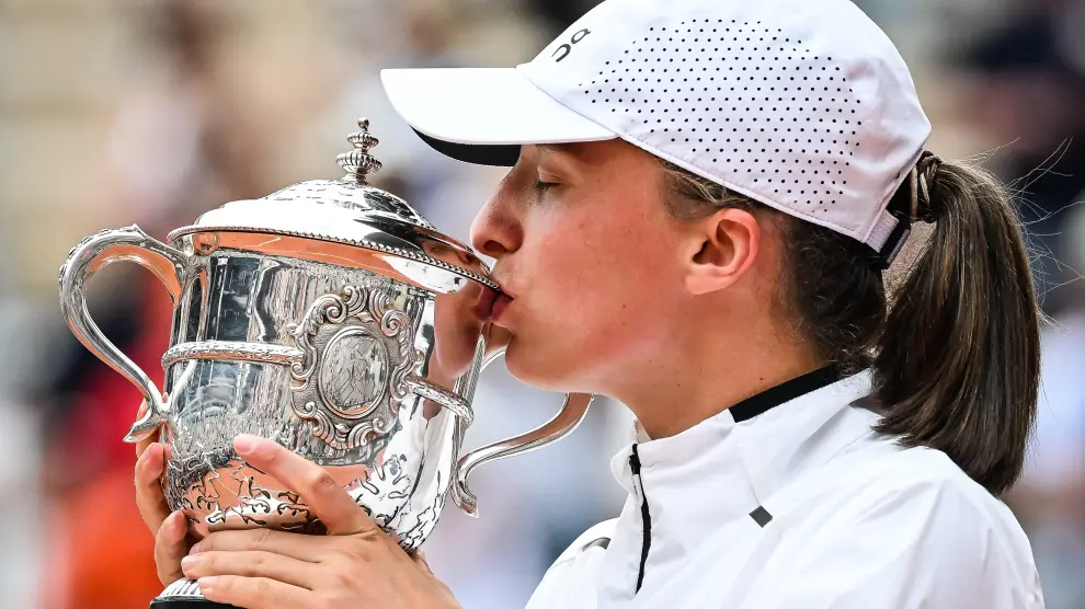 Iga Swiatek besa la copa que la acredita como ganadora de Roland Garros 2023.