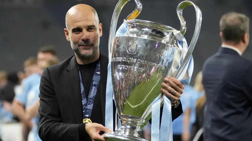 Manchester City's head coach Pep Guardiola holds the trophy after winning the Champions League final soccer match between Manchester City and Inter Milan at the Ataturk Olympic Stadium in Istanbul, Turkey, Sunday, June 11, 2023. Manchester City won 1-0. (AP Photo/Francisco Seco)
