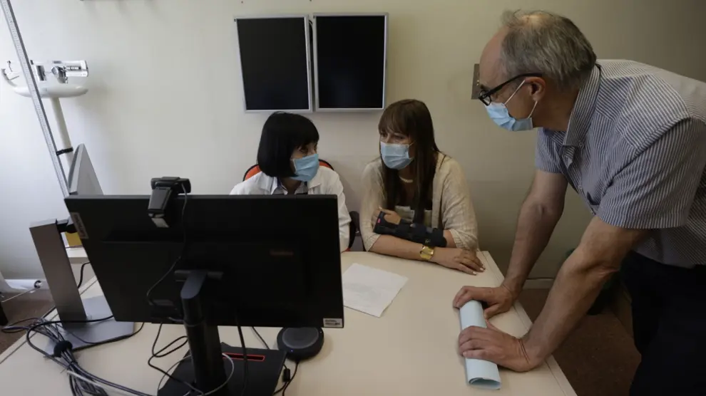 La jefa de servicio de Neurología del Clínico comprueba el funcionamiento de una videoconsulta, junto a Sira Repollés y Juan Coll.