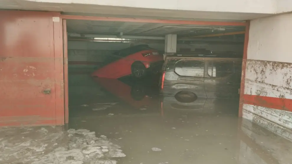 Dos coches flotan en el interior de un garaje de Cuarte de Huerva, inundado tras la tormenta de este jueves.