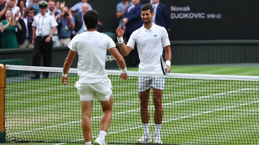 Tennis - Wimbledon - All England Lawn Tennis and Croquet Club, London, Britain - July 16, 2023 Spain's Carlos Alcaraz with Serbia's Novak Djokovic after winning the final REUTERS/Toby Melville