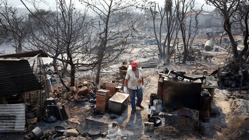 Dervenochoria (Greece), 19/07/2023.- A local resident inspects the damage on his property, which has been completely destroyed due to a wildfire, in Dervenochoria, northwest of Attica region, Greece, 19 July 2023. West Attica and Loutraki passed another difficult night of wildfires that have been raging since 17 July, burning houses and destroying the natural environment in their passing. In Dervenochoria, the blaze still burns despite the huge efforts to contain it. Five aircrafts and eight helicopters took off at first light and started dropping water. (incendio forestal, Grecia) EFE/EPA/ORESTIS PANAGIOTOU