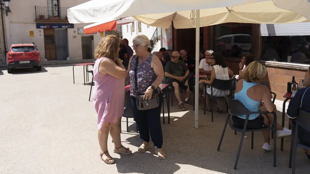 La alcaldesa, Raquel Benedí, a la izquierda, conversa con una vecina en la plaza de Castellote.