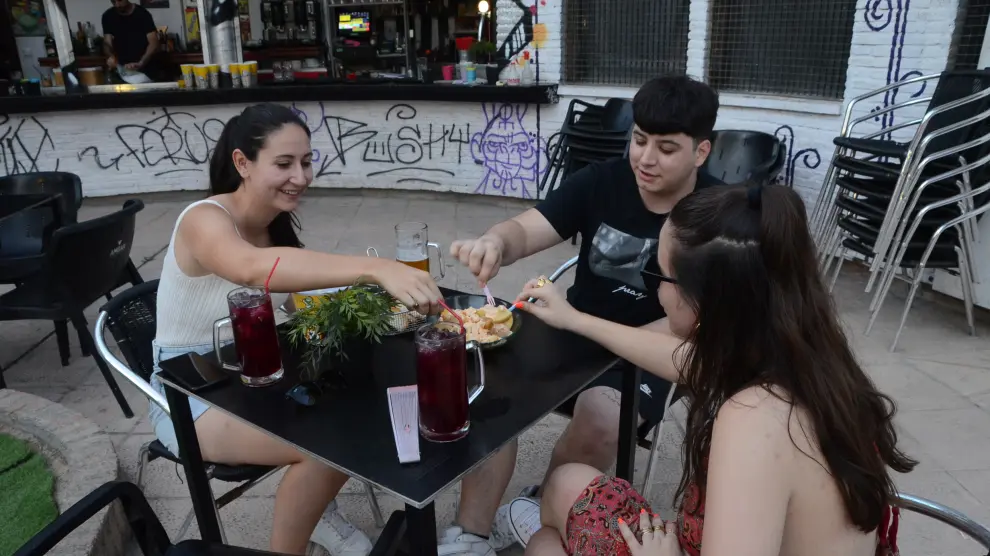 Tres jóvenes degustando las patatas rockeras de El Balcón de Las Fuentes