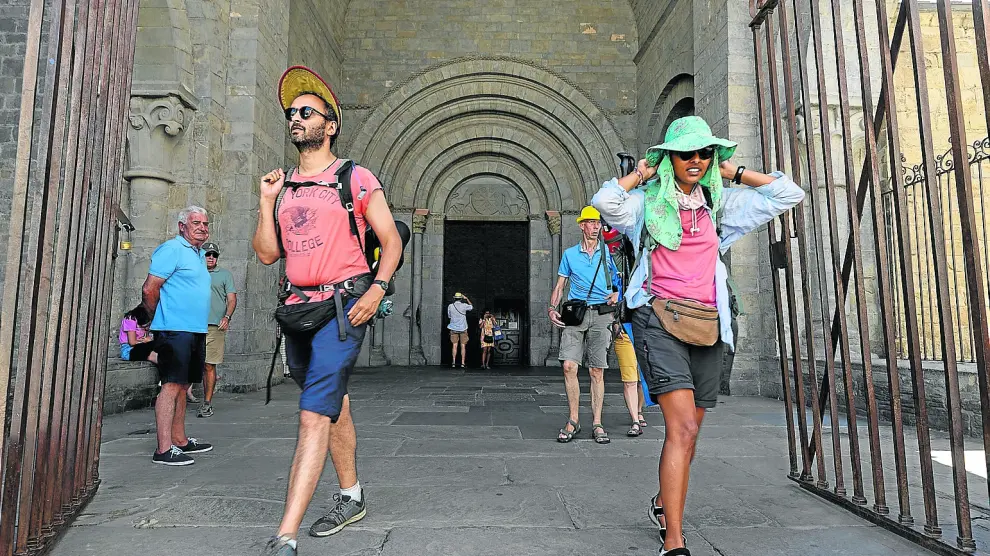 Turistas, ayer saliendo y entrando de la Catedral de Jaca, localidad muy concurrida durante el puente de agosto.