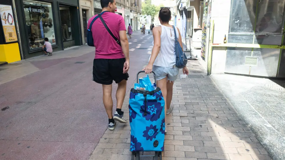 Los jóvenes Mario Gregorio y Pilar Gómez tras hacer la compra en la calle Cinco de Marzo de Zaragoza.