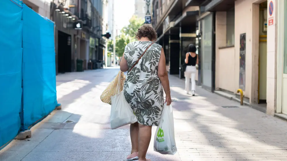 Una mujer hace la compra en la calle Cinco de Marzo de Zaragoza.