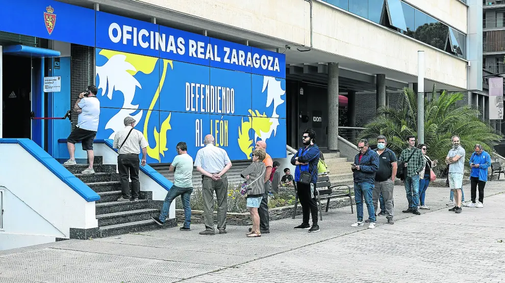 Aficionados del Real Zaragoza haciendo fila en las oficinas del club
