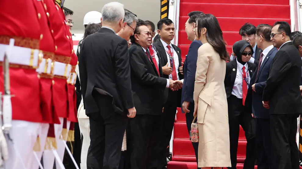 El presidente surcoreano Yoon Suk Yeol, junto a su esposa, Kim Keon Hee, saluda a funcionarios indonesios en el aeropuerto internacional Soekarno-Hatta de Yakarta, Indonesia.