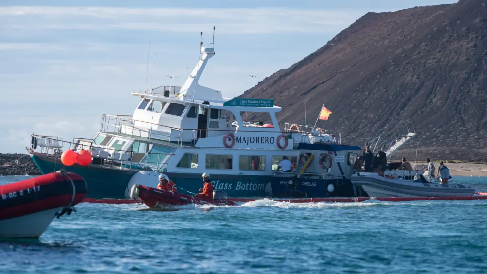 El barco turístico 'El Majorero', que cubre el trayecto entre el islote de Lobos y Corralejo, en el norte de Fuerteventura, semihundido al haber chocado los cristales del fondo de la embarcación con las rocas del fondo marino