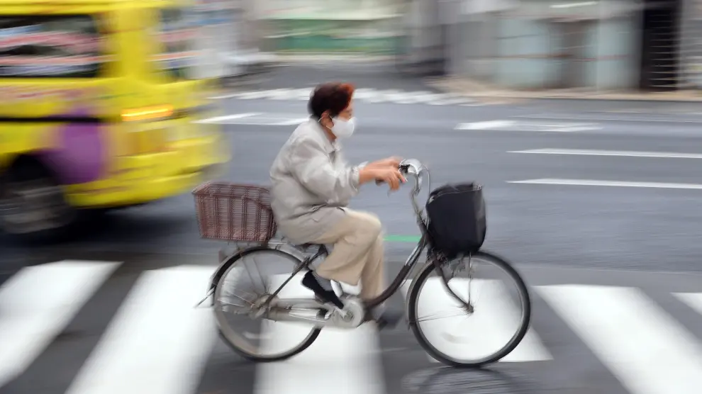 Una mujer mayor va en bici en el barrio de Nihionbashi en Tokyo.