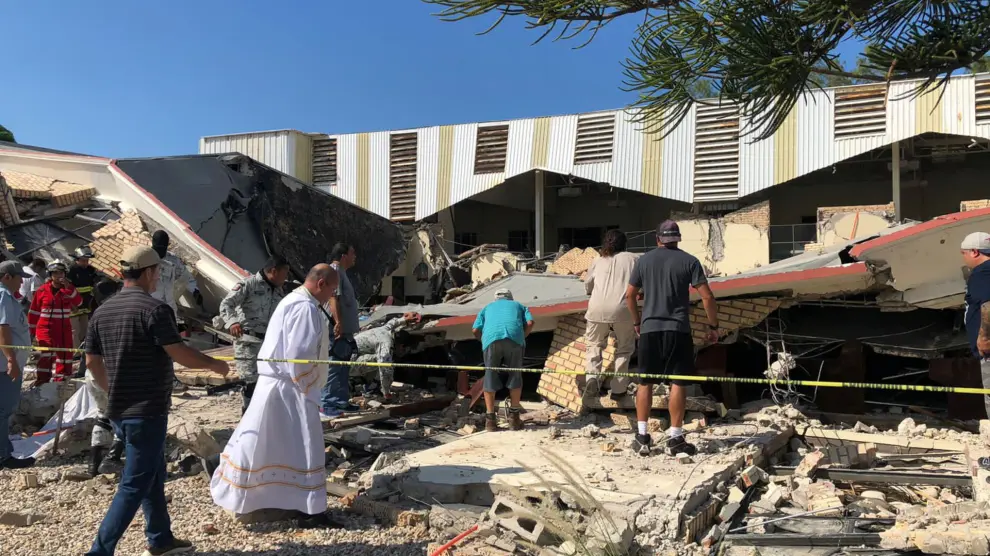Miembros de las fuerzas de seguridad, personas y un sacerdote trabajan en un lugar donde el techo de una iglesia se derrumbó durante la misa dominical en Ciudad Madero, en el estado de Tamaulipas, México.
