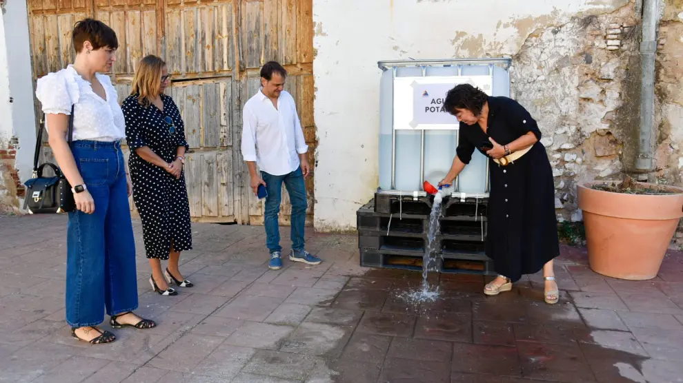 La alcaldesa de Torrellas muestra dónde se encuentra el depósito de agua potable que se ha instalado en la localidad.