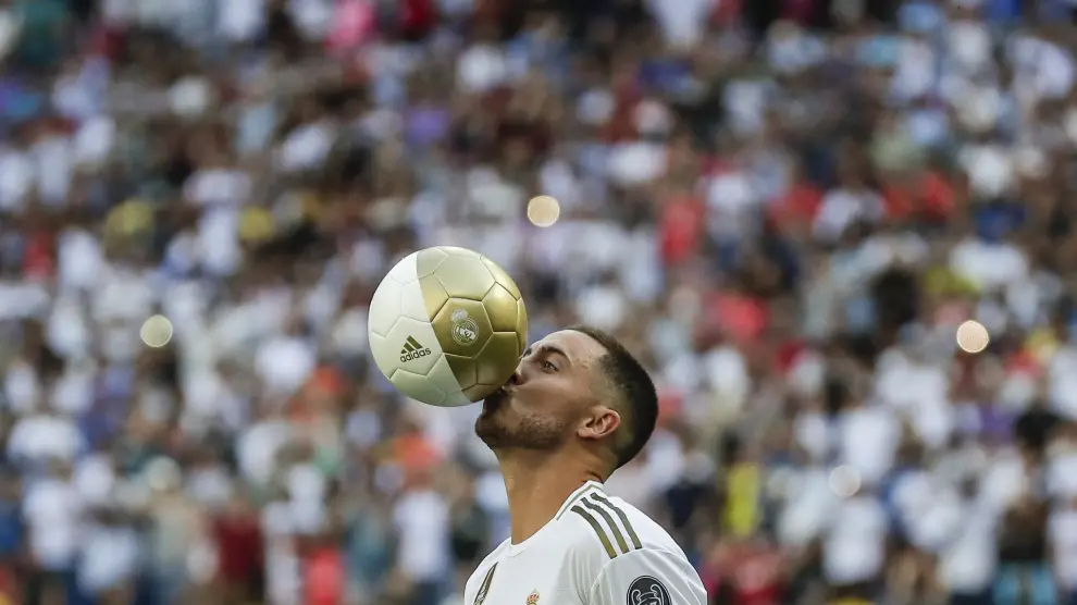 El delantero belga Eden Hazard besa el balón durante su presentación oficial tras fichar por el Real Madrid en el estadio Santiago Bernabeu en Madrid, el jueves 13 de junio de 2019.