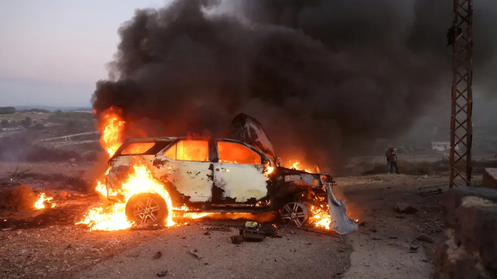 Un coche de periodistas arde en el lugar donde el cámara de Reuters Isam Abdulá resultó muerto y otros reporteros heridos, al parecer tras un ataque con misiles procedentes de posiciones israelíes en Alma Al-Shaab, cerca de la frontera con Israel, en el sur del Líbano