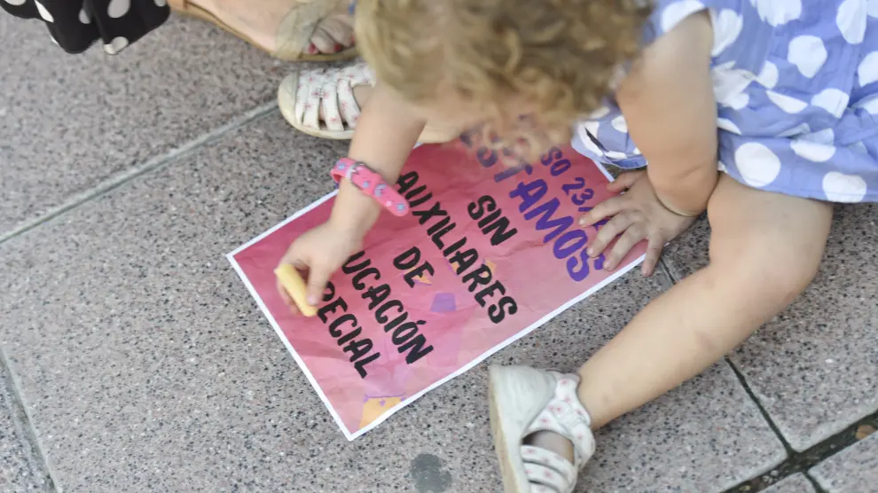 Una niña dibuja en un cartel durante la concentración del 10 de octubre en Huesca para pedir más auxiliares de educación especial.