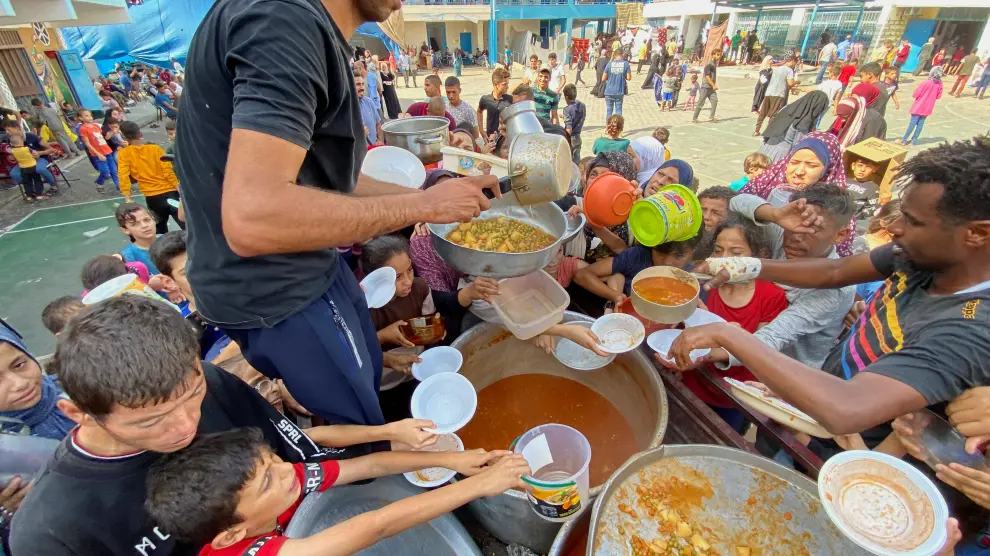 Ciudadanos palestinos van a por comida cerca del paso de Rafah
