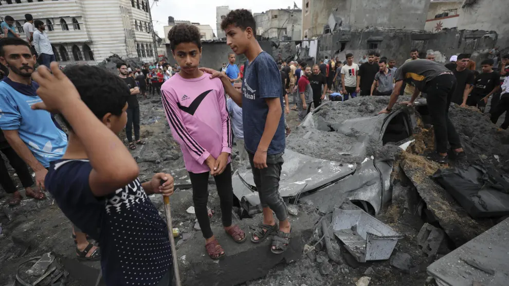 Palestinians inspect the rubble of a destroyed building after an Israeli airstrike in Deir al Balah, Gaza Strip, Friday, Oct. 27, 2023. (AP Photo/Ali Mahmoud)