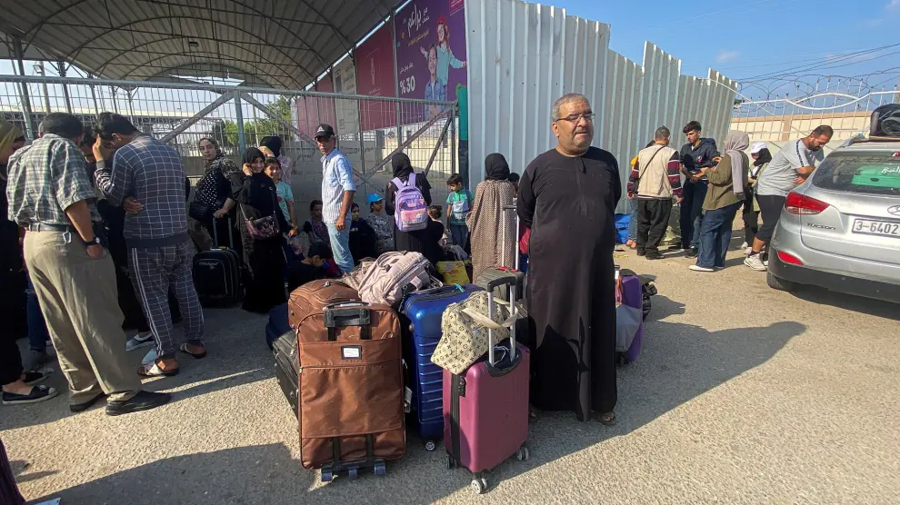 Palestinos con doble ciudadanía esperan fuera del cruce fronterizo de Rafah con Egipto