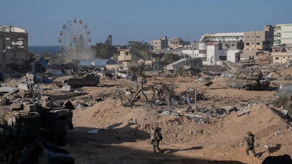 Soldados irsaelíes andando por una zona atacada en Gaza