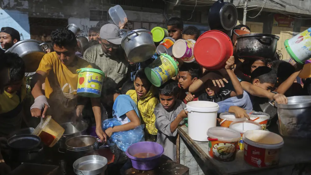 Palestinos esperan la distribución de alimentos en Rafah, en el sur de la Franja de Gaza