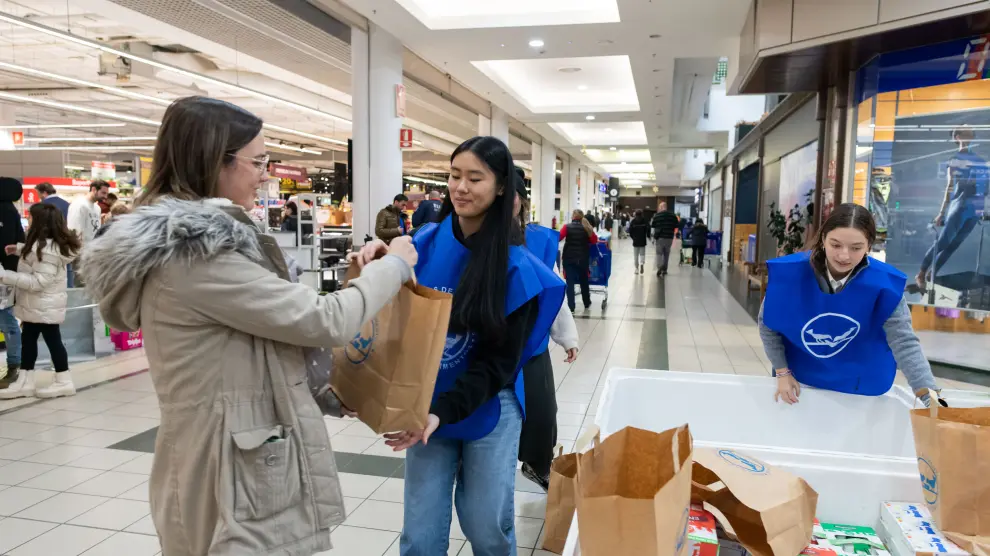 Una donante entrega una bolsa con productos a una voluntaria, este sábado en un Carrefour.