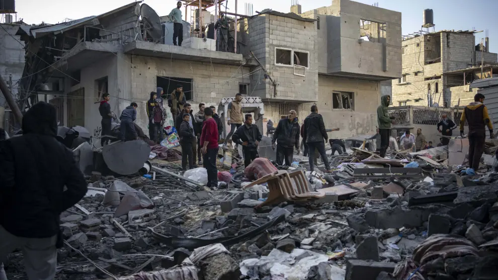 Palestinians look at houses destroyed in the Israeli bombardment of the Gaza Strip in Rafah on Saturday, Dec. 9, 2023. (AP Photo/Fatima Shbair)