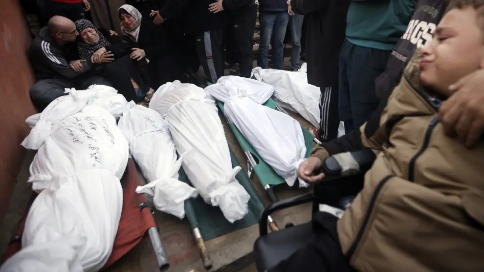 Palestinians mourn relatives killed in the Israeli bombardment of the Gaza Strip outside a morgue in Khan Younis on Sunday, Dec. 10, 2023. (AP Photo/Mohammed Dahman)