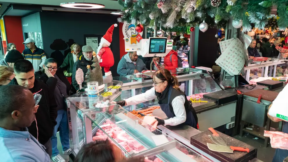 Varios clientes esperan su turno en una de las carnicerías del Mercado Central de Zaragoza