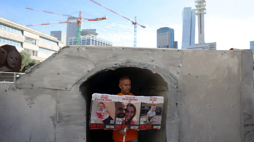 Un hombre muestra en Tel Aviv imágenes de sus familiares secuestrados por Hamas MIDEAST ISRAEL PALESTINIANS GAZA CONFLICT