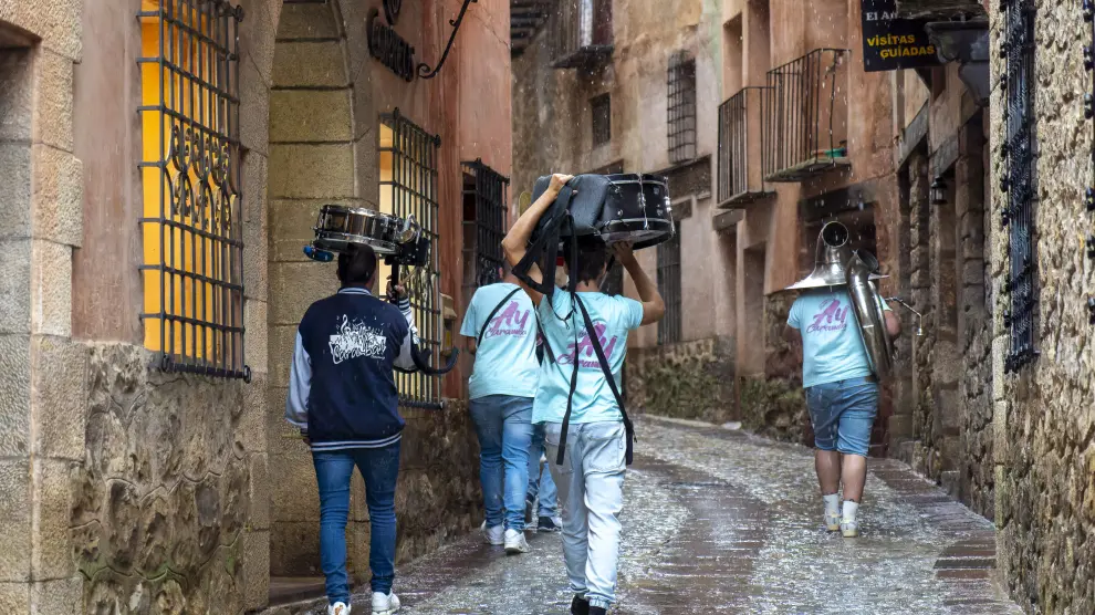 Un grupo de turistas recorre las calles de Albarracín bajo la lluvia.