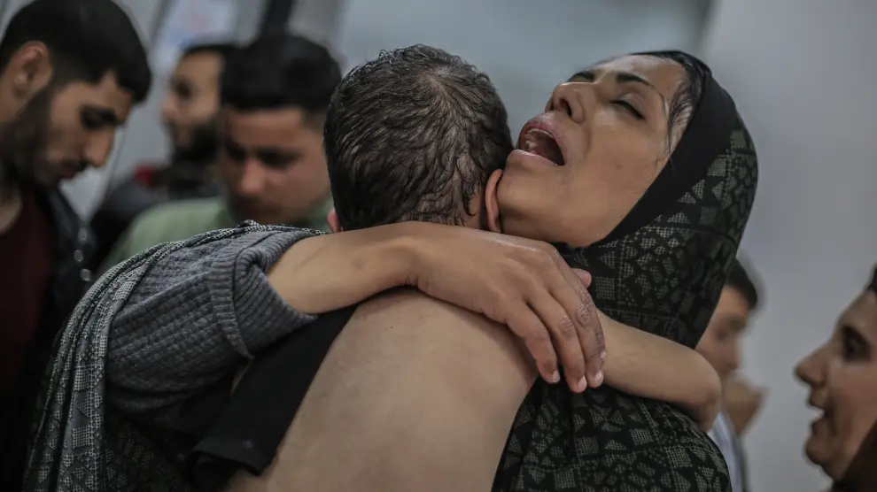 Una mujer palestina abraza a su hijo en Rafah. Aproximadamente un millón de los 1,9 millones de personas desplazadas de la zona son mujeres y niñas