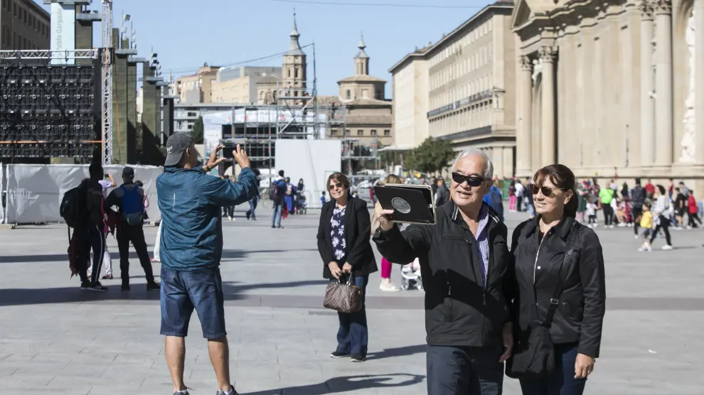Varios turistas se fotografían delante de la basílica del Pilar.