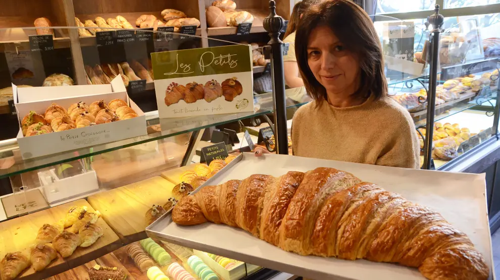 La propietaria de The Petite Croissant, Anne-Laure Romeuf, con un croissant gigante.