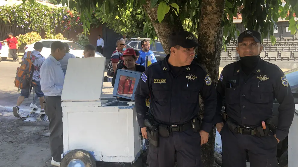 Dos policías vigilan la entrada al centro electoral Centro Escolar Concha Viuda de Escalón.