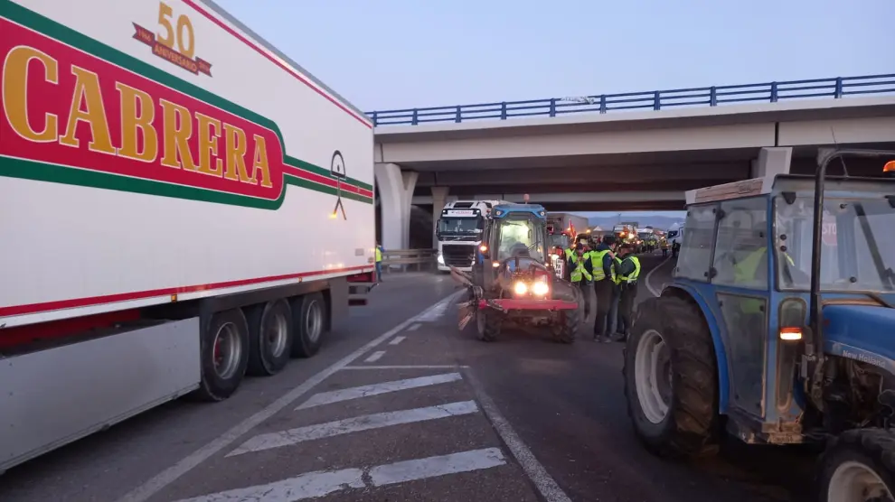 Los tractores bloquean la rotonda de enlace entre la A220 y la A122, con varios camiones detenido en La Almunia de Doña Godina.