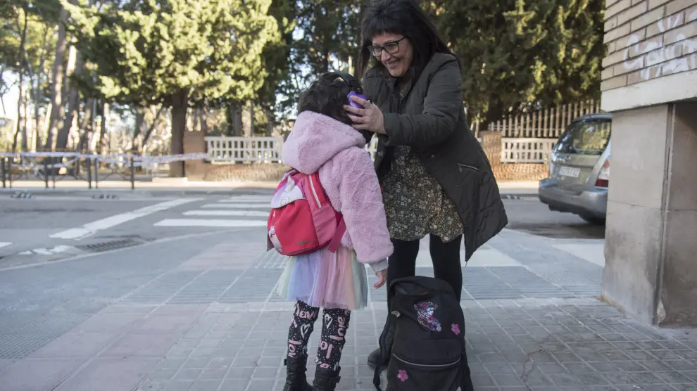 Marisa Martínez coloca a su hija los cascos de reducción de sonido cerca del Parque Miguel Servet de Huesca