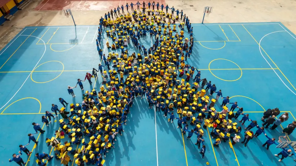 Alumnos de primaria del colegio Santo Domingo de Silos de Zaragoza han formado un lazo dorado, símbolo internacional de la lucha contra el cáncer infantil.