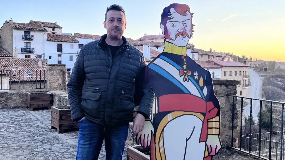 Un visitante posa junto a la imagen del pretendiente Carlos María Isidro en La Iglesuela del Cid.