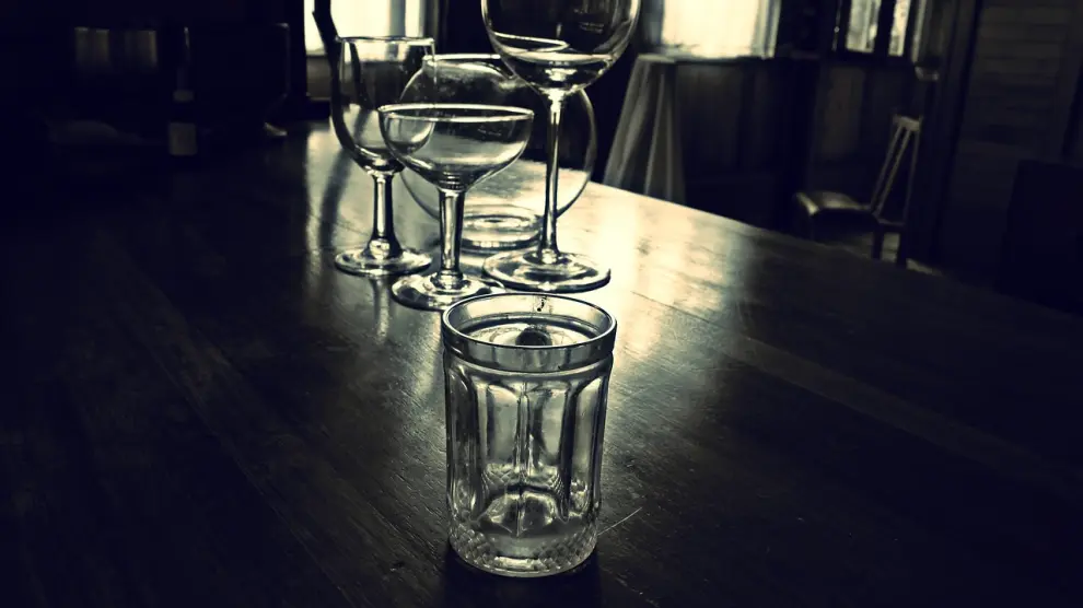 Grandes copas de vino en la mesa junto a la jarra con vino