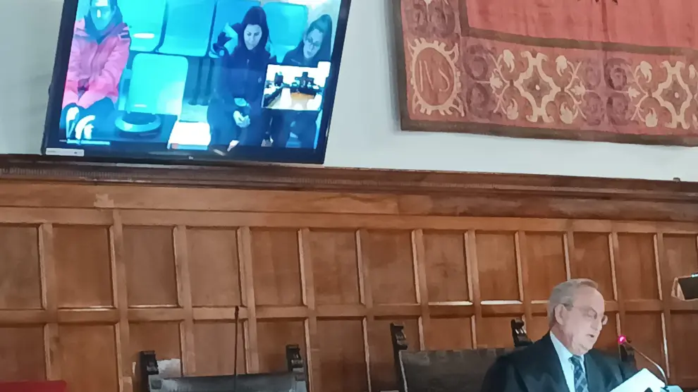 La madre y el padrastro de Laia asistieron a la vista por videoconferencia. Debajo de la pantalla, el fiscal del TSJA Enrique Pera.