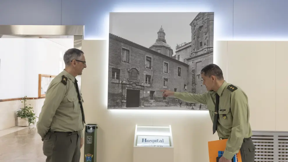 El teniente coronel Alfredo Martín le muestra al director del Hospital Militar, Juan Antonio Lara, un detalle de la fotografía y una ceramíca del anterior hospital militar en la entrada del Hospital General de la Defensa esta semana.