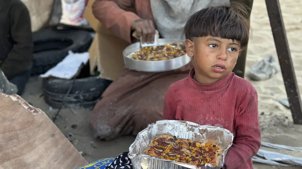Un niño come un plato del Iftar, que marca la ruptura del ayuno en ramadán en Rafah, Gaza.