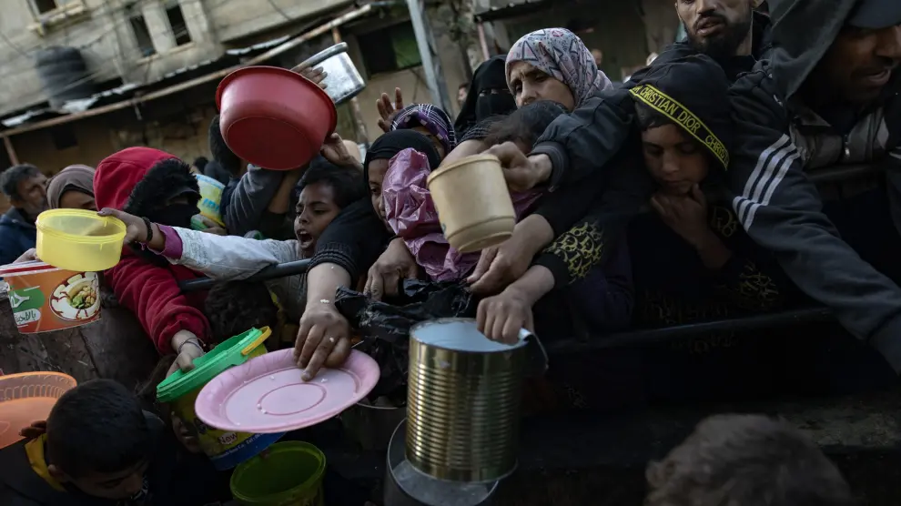 Centenares de palestinos esperan por comida en la Franja de Gaza.