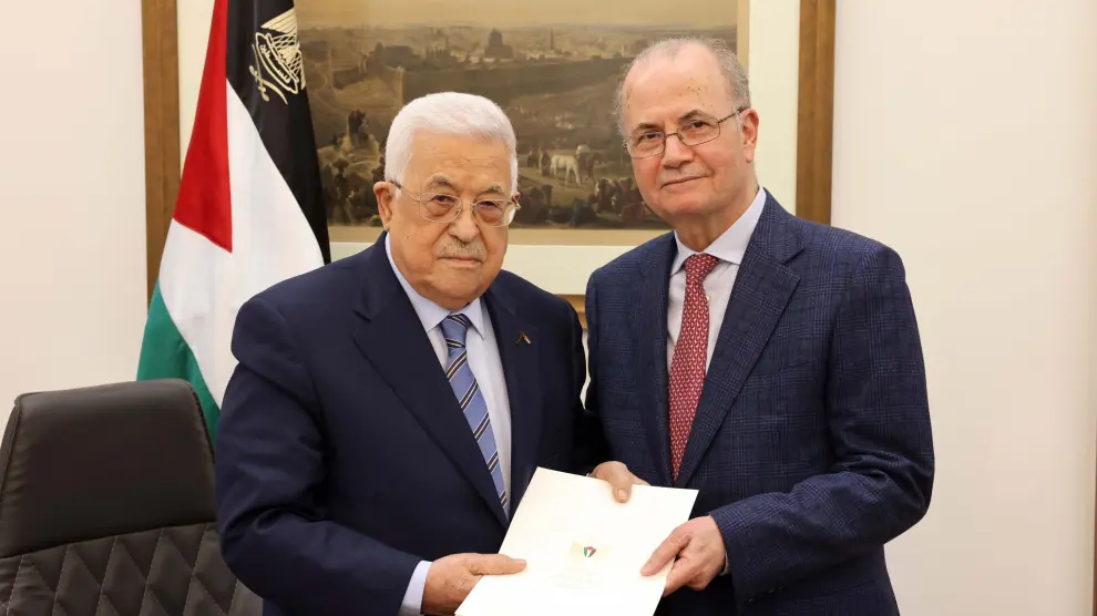 El presidente palestino Mahmoud Abbas (izq.) entrega un mandato a Mohammad Mustafa en la ciudad cisjordana de Ramallah
