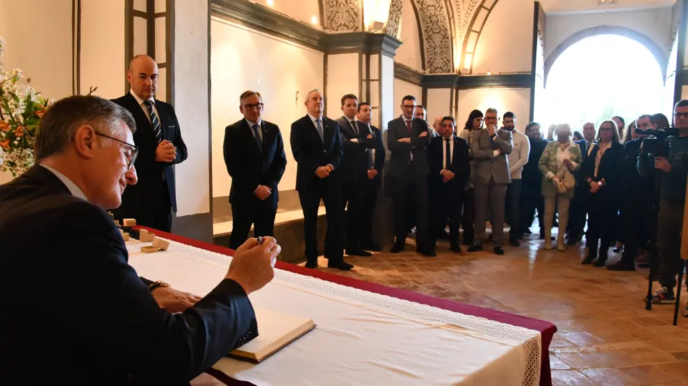 El consejero de Turismo, Manuel Blasco, firma en el Libro de Honor en Urrea de Gaén.
