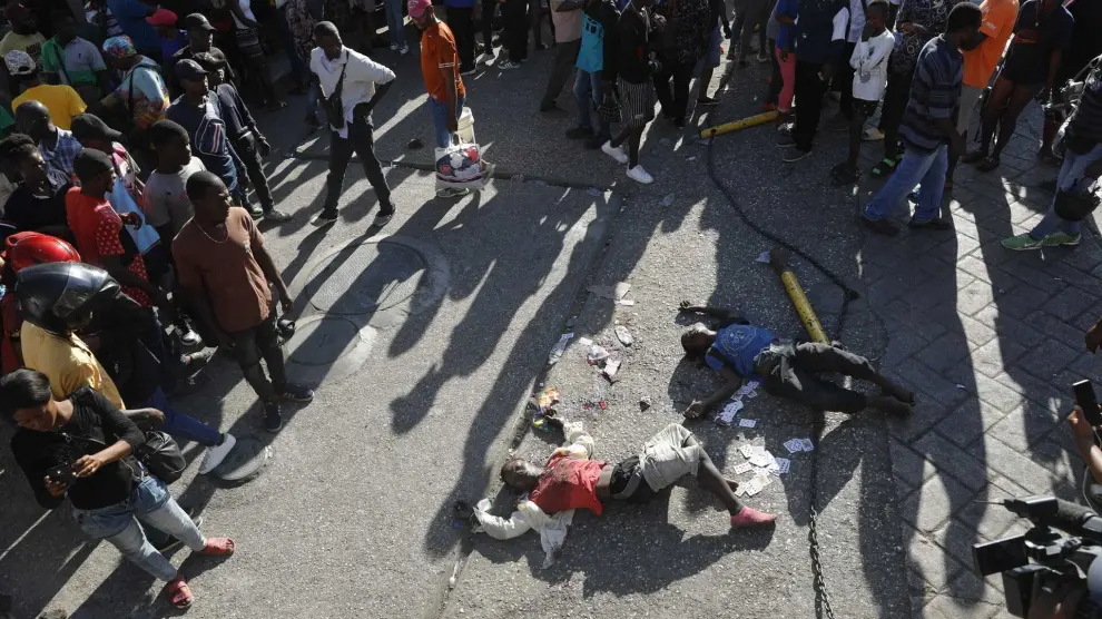 EDS NOTE: GRAPHIC CONTENT - The bodies of two people lie on the street after an overnight shooting in the Petion Ville neighborhood of Port-au-Prince, Haiti, Monday, March 18, 2024. (AP Photo/Odelyn Joseph) Associated Press / LaPresse Only italy and Spain