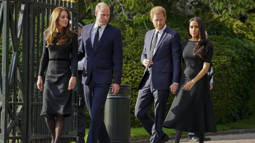 FILE - Britain's Prince William, second left, Kate, Princess of Wales, left, Britain's Prince Harry, second right, and Meghan, Duchess of Sussex view the floral tributes for the late Queen Elizabeth II outside Windsor Castle, in Windsor, England on Sept. 10, 2022. (AP Photo/Martin Meissner, File)